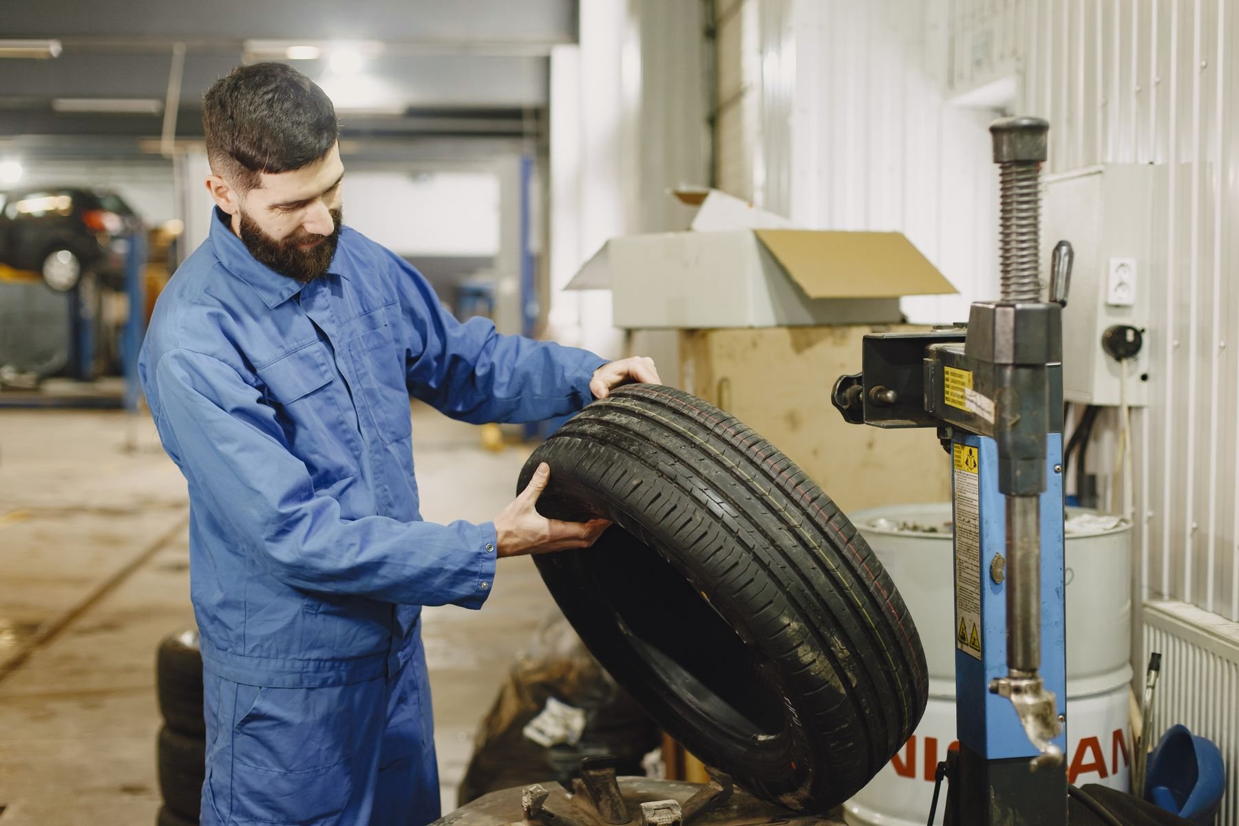 Technician seating a passenger tire on a professional tabletop rim-clamp tire changer